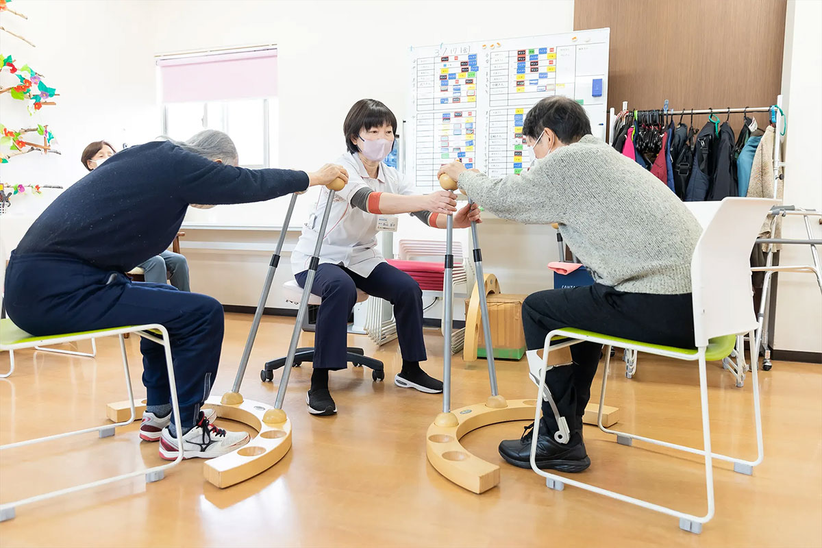 豊中市の整形外科かとう整形在宅クリニックの通所リハビリテーション（デイケア）の専用の道具で集団エクササイズ